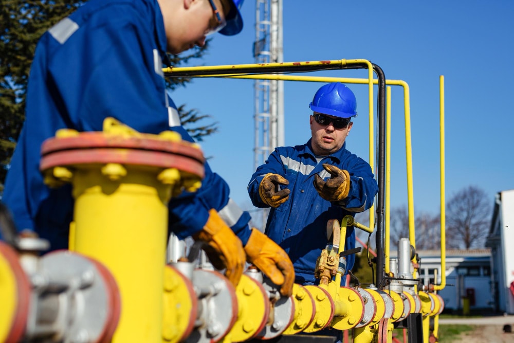 Técnicos qualificados operando equipamentos industriais em terminal de gás, demonstrando a importância da formação técnica adequada para trabalhar na Petrobras