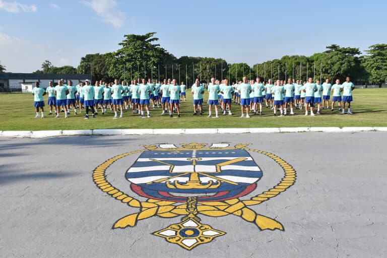 Candidatos do concurso SMV 2026 em formação durante treino físico na Marinha do Brasil com brasão oficial