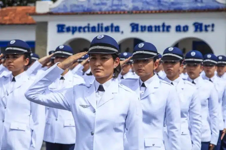 Oficiais femininas da Força Aérea Brasileira em formação durante cerimônia militar com uniforme branco de gala