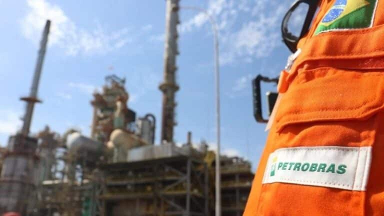 Profissional da Petrobras em uniforme laranja observando instalações industriais - como estudar para concurso Petrobras 2026
