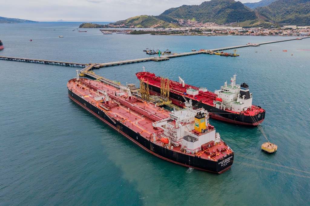 Navios-tanque da Transpetro atracados em terminal portuário no Brasil, com vista aérea do porto ao fundo