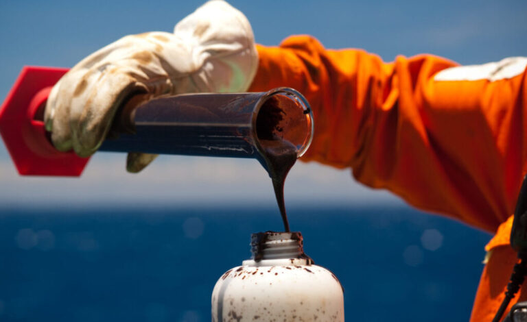 Técnico da Petrobras coletando amostra de petróleo bruto em frasco em operação offshore