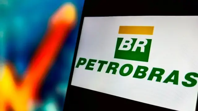 Logo da Petrobras em tela com gráfico de crescimento desfocado ao fundo