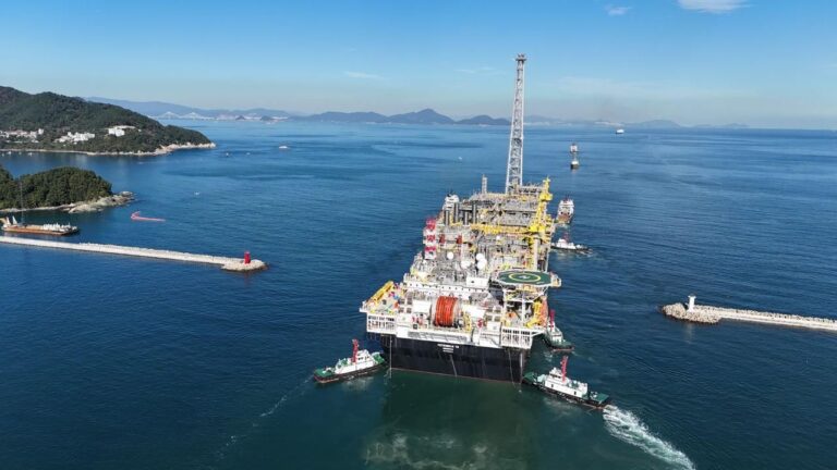 Plataforma FPSO P-79 da Petrobras saindo de estaleiro com rebocadores de apoio